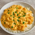 Creamy Smothered Chicken and Rice served on a rustic plate