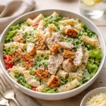 Easy Chicken Caesar Pasta Salad in a bowl with creamy dressing and croutons.