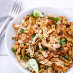 Mexican Pulled Chicken in skillet with lime and cilantro