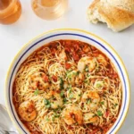 Shrimp Marinara pasta dish with basil and garlic bread