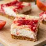 Strawberry Cheesecake Bars sliced on parchment paper