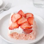 Strawberry Tres Leches Cake slice with whipped cream and strawberries