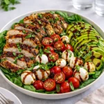 A bowl of Baked Marinated Chicken Salad with avocado and mozzarella.