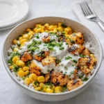 Delicious Street Corn Chicken Rice Bowl topped with avocado and lime