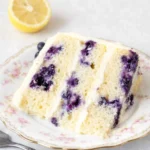 Lemon Blueberry Cake on a stand with cream cheese frosting