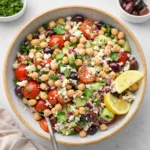 A vibrant Mediterranean Chickpea Salad in a glass bowl with feta and herbs.