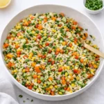A vibrant bowl of Rainbow Orzo Salad with colorful vegetables and fresh herbs.