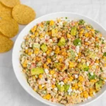 Street Corn Chicken Salad in a bowl with lime and tortilla chips