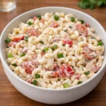 Creamy Cajun Pasta Salad with chicken and vegetables in a white bowl.