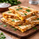 A plate of crispy Easy Chicken Quesadillas with salsa and guacamole.